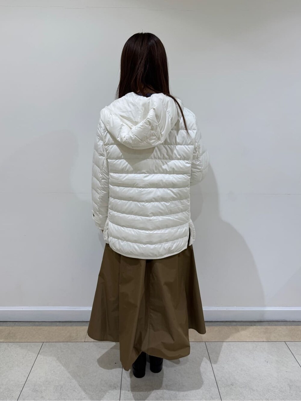 ホワイト系のダウンジャケット/コート、ブルー系のシャツ/ブラウス、ブラウン系のスカートを着用したレディースの冬コーディネートの4枚目の写真
