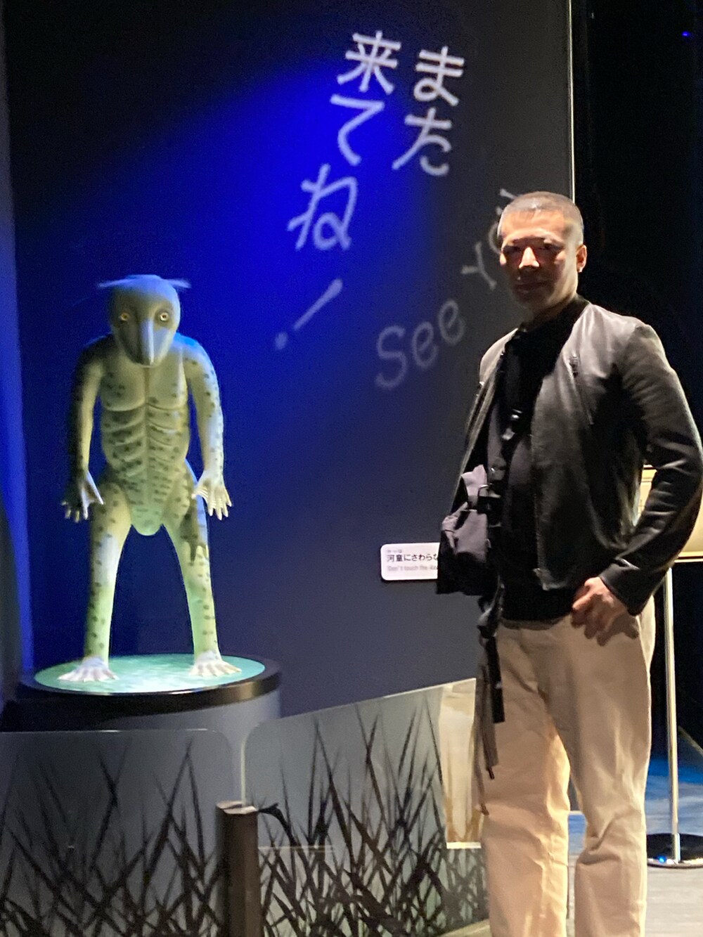 ピンク系のデニムパンツ、グリーン系のスニーカー、ブラック系のライダースジャケットを着用したメンズの春コーディネートの2枚目の写真