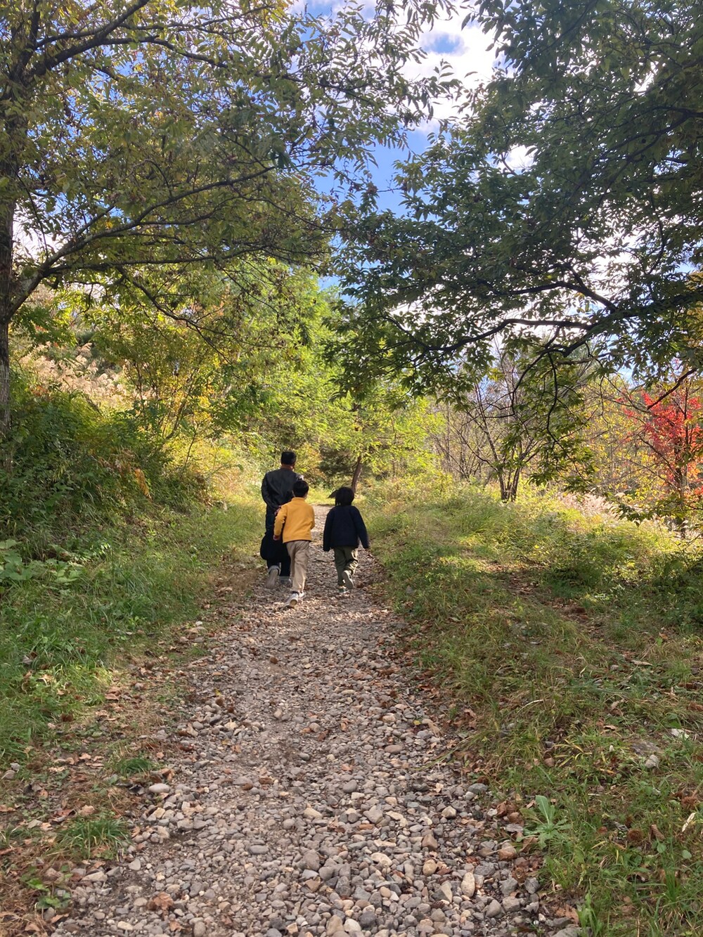 ブルー系のデニムパンツ、ブラック系のショルダーバッグ、ブラック系のライダースジャケットを着用したメンズの秋コーディネートの2枚目の写真