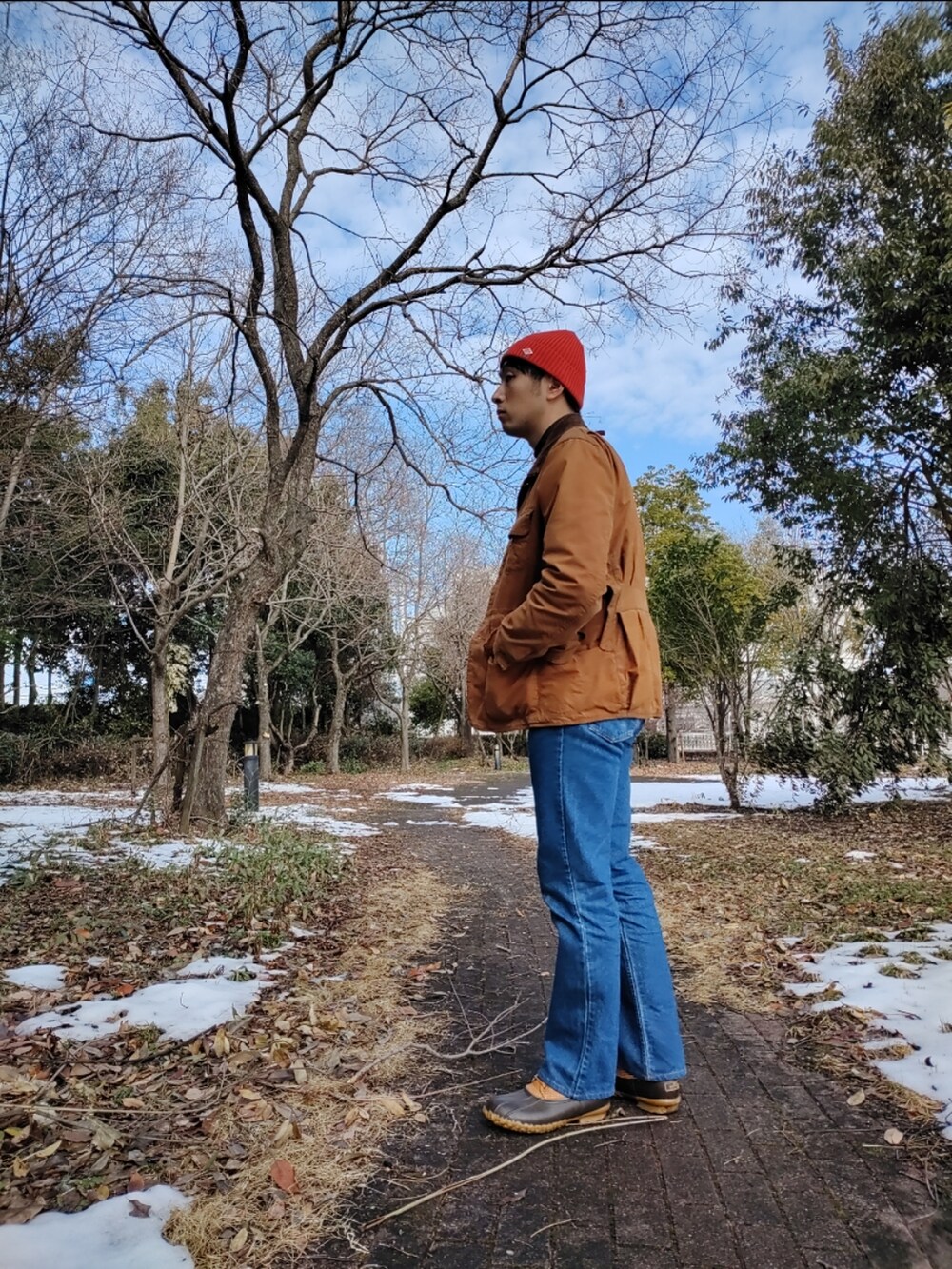 ブラウン系のその他アウター、その他のニット/セーター、ブルー系のデニムパンツを着用したメンズの冬コーディネートの2枚目の写真