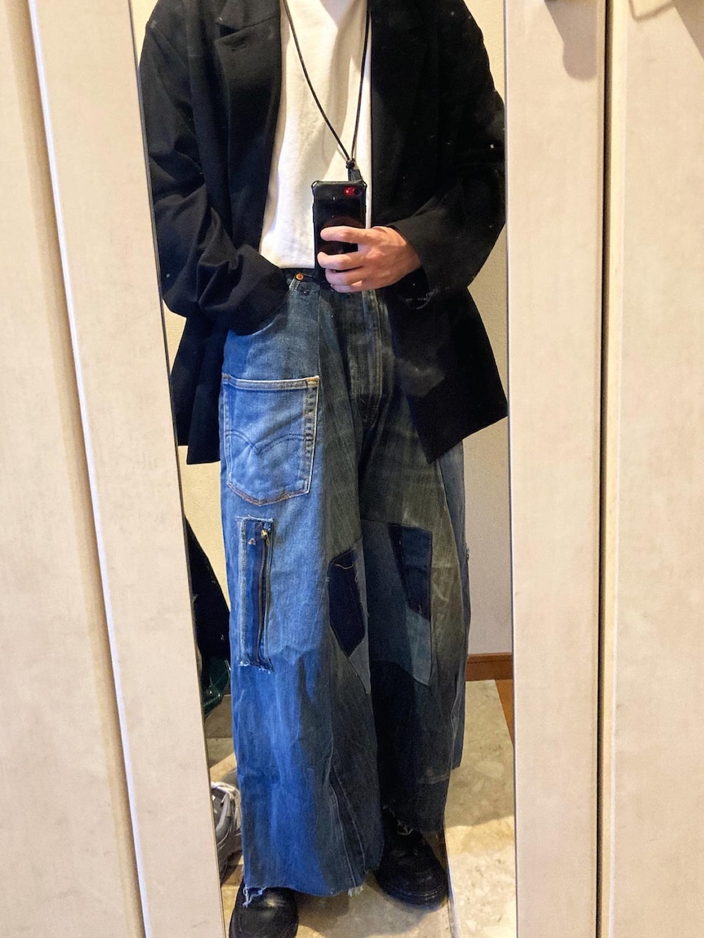 ホワイト系のTシャツ/カットソー、ブルー系のデニムパンツ、ブラック系のドレスシューズを着用したメンズの秋コーディネートの2枚目の写真