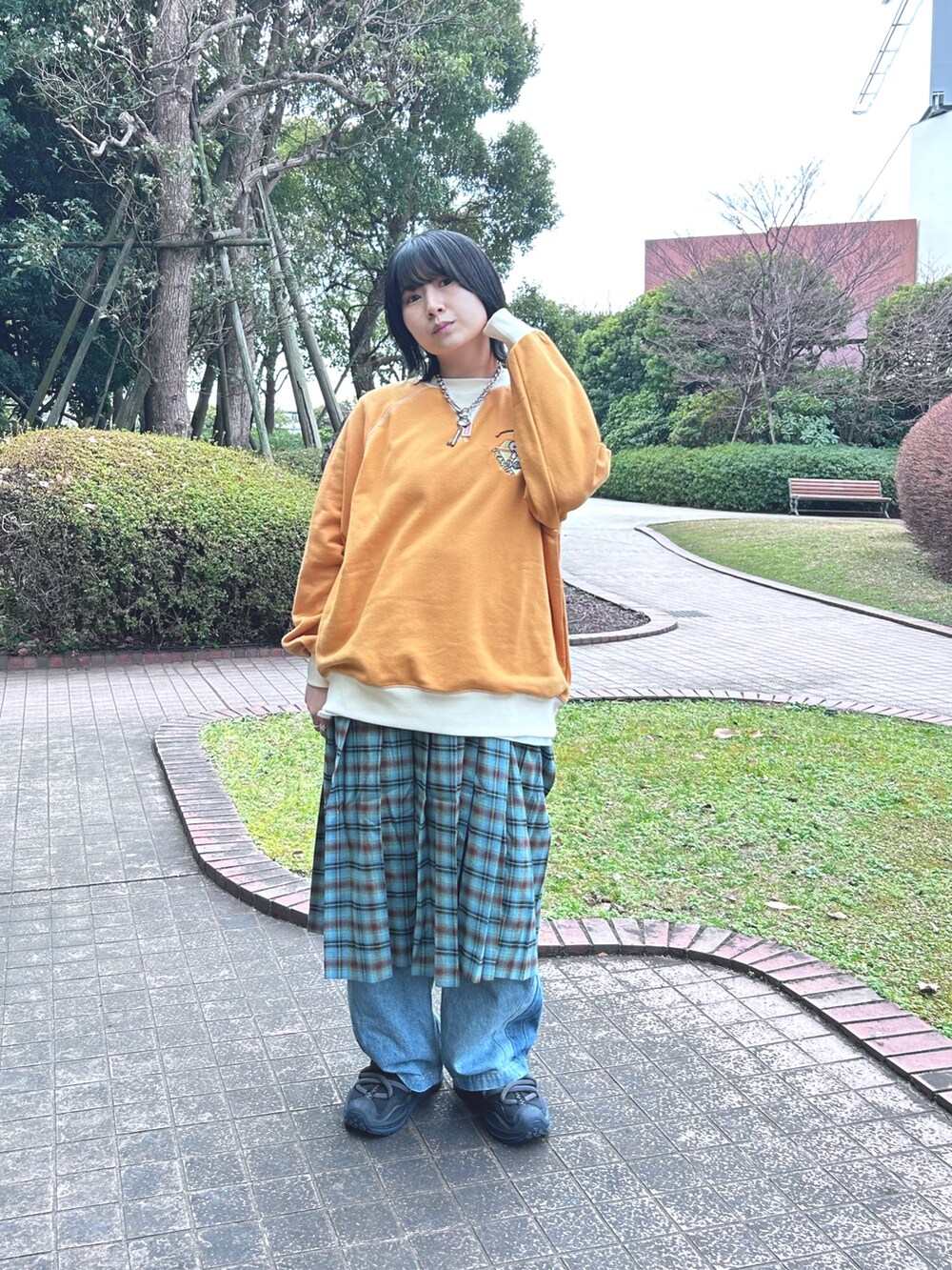 オレンジ系のスウェット、ブルー系のスカートを着用したレディースの冬コーディネートの3枚目の写真