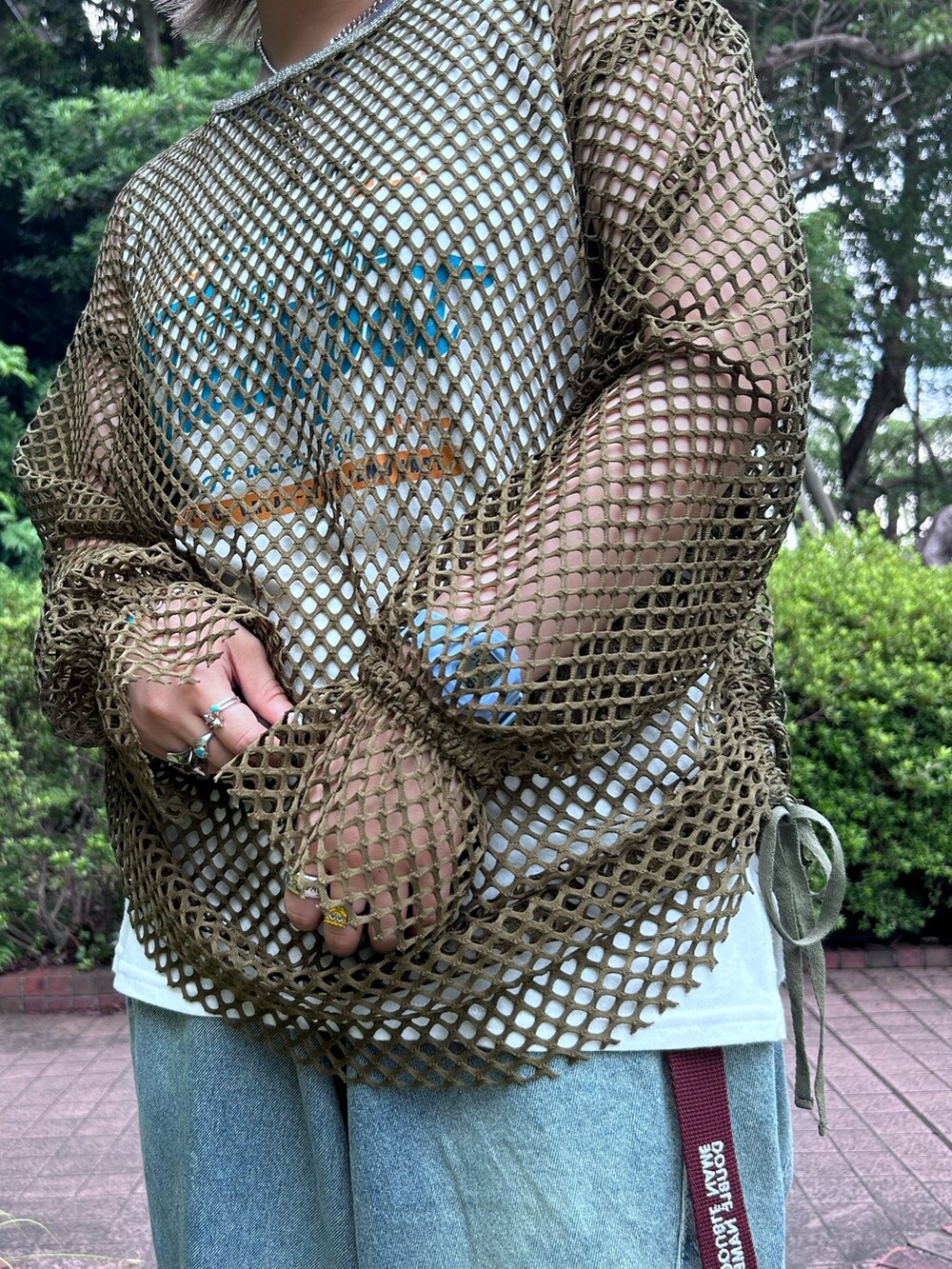 グリーン系のシャツ/ブラウス、ブルー系のデニムパンツを着用したレディースの夏コーディネートの3枚目の写真