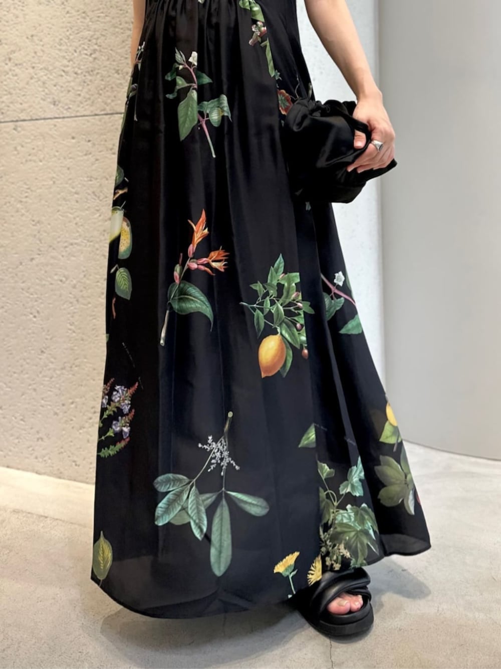 ブラック系のショルダーバッグ、ブラック系のサンダル、ブラック系のワンピースを着用したレディースの夏コーディネートの3枚目の写真