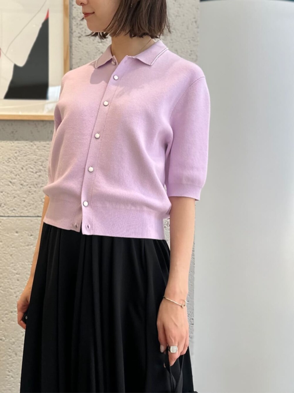 ブラック系のワンピース、ブラック系のサンダル、パープル系のカーディガン/ボレロを着用したレディースの春コーディネートの2枚目の写真