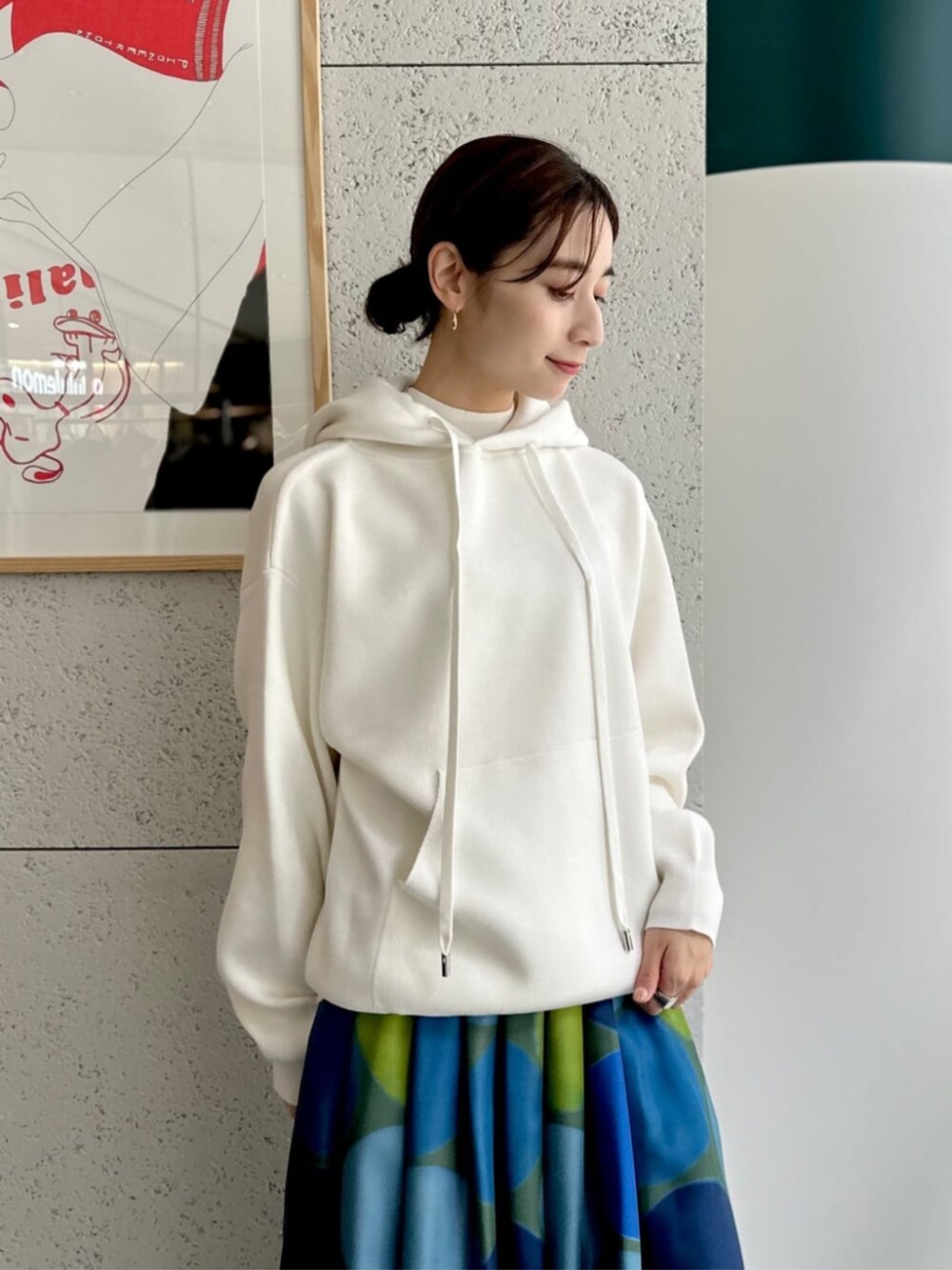 イエロー系のショルダーバッグ、ホワイト系のニット/セーター、ブルー系のスカートを着用したレディースの秋コーディネートの3枚目の写真