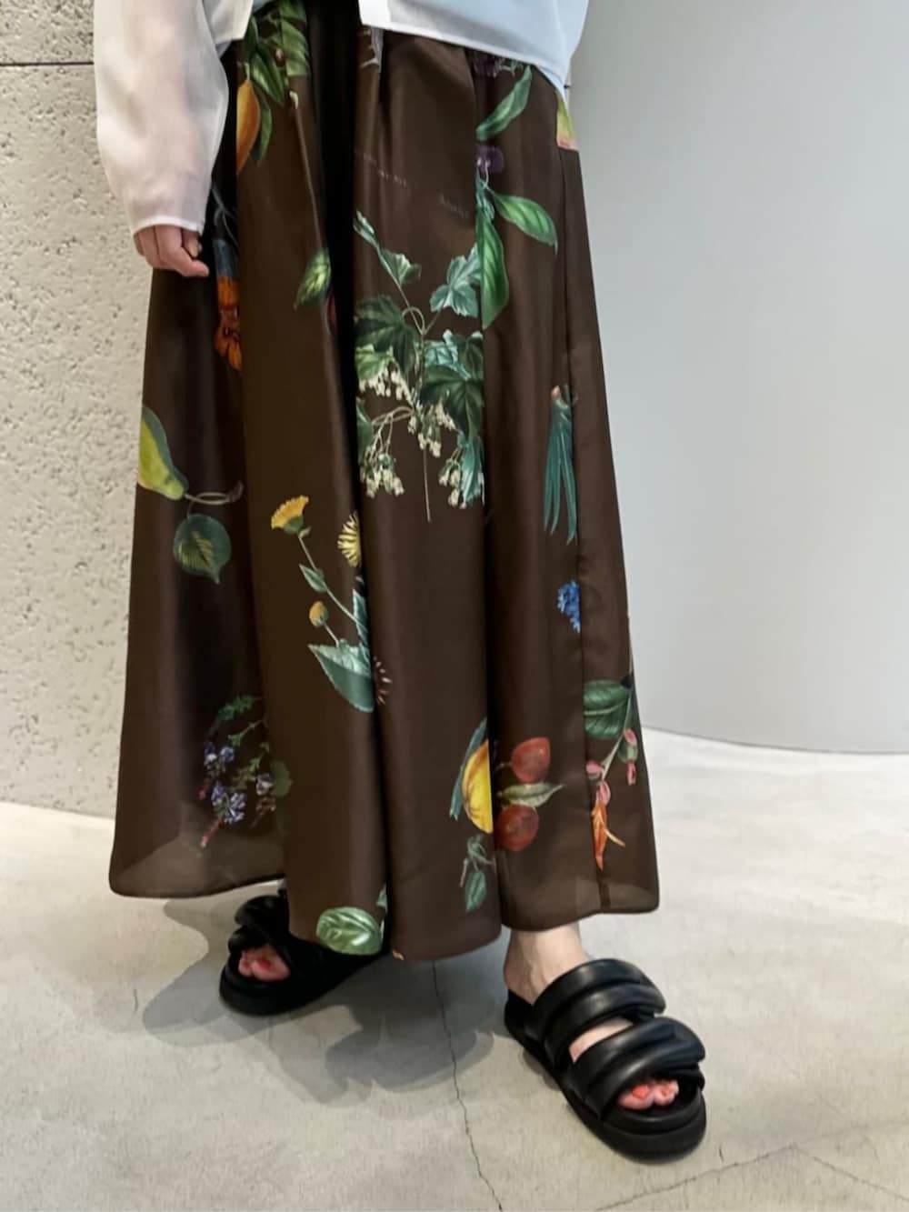 ブラック系のサンダル、ブラウン系のスカート、ホワイト系のニット/セーターを着用したレディースの夏コーディネートの3枚目の写真