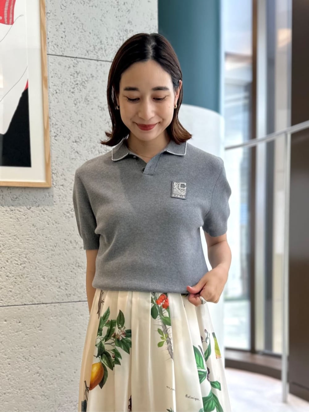 ベージュ系のサンダル、グレー系のニット/セーター、ホワイト系のスカートを着用したレディースの夏コーディネートの2枚目の写真