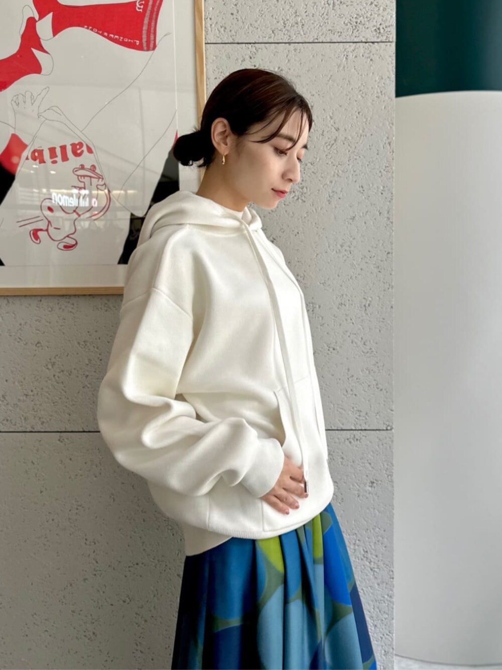 イエロー系のショルダーバッグ、ホワイト系のニット/セーター、ブルー系のスカートを着用したレディースの秋コーディネートの2枚目の写真