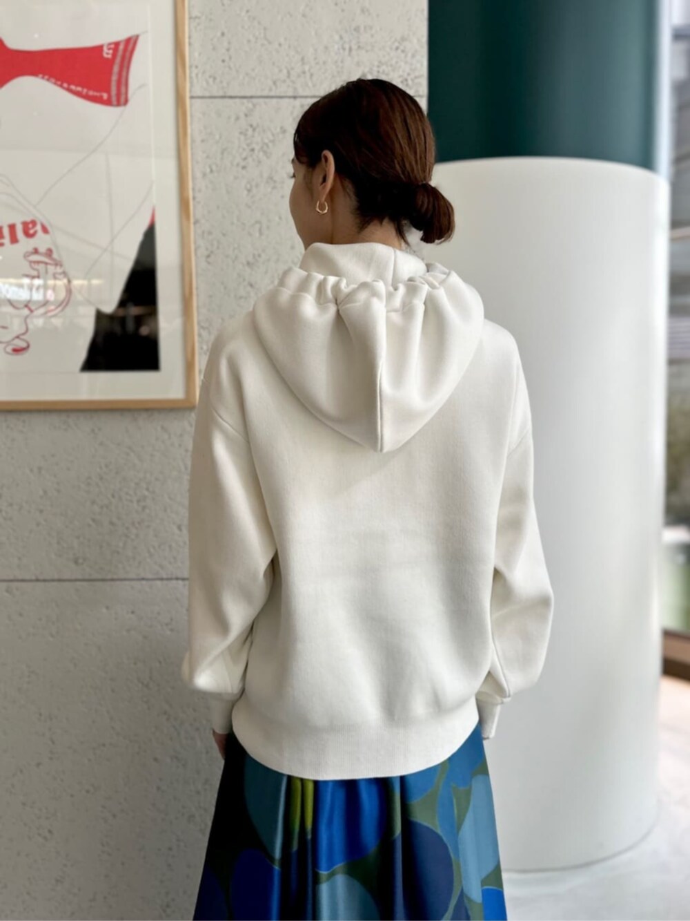 イエロー系のショルダーバッグ、ホワイト系のニット/セーター、ブルー系のスカートを着用したレディースの秋コーディネートの4枚目の写真