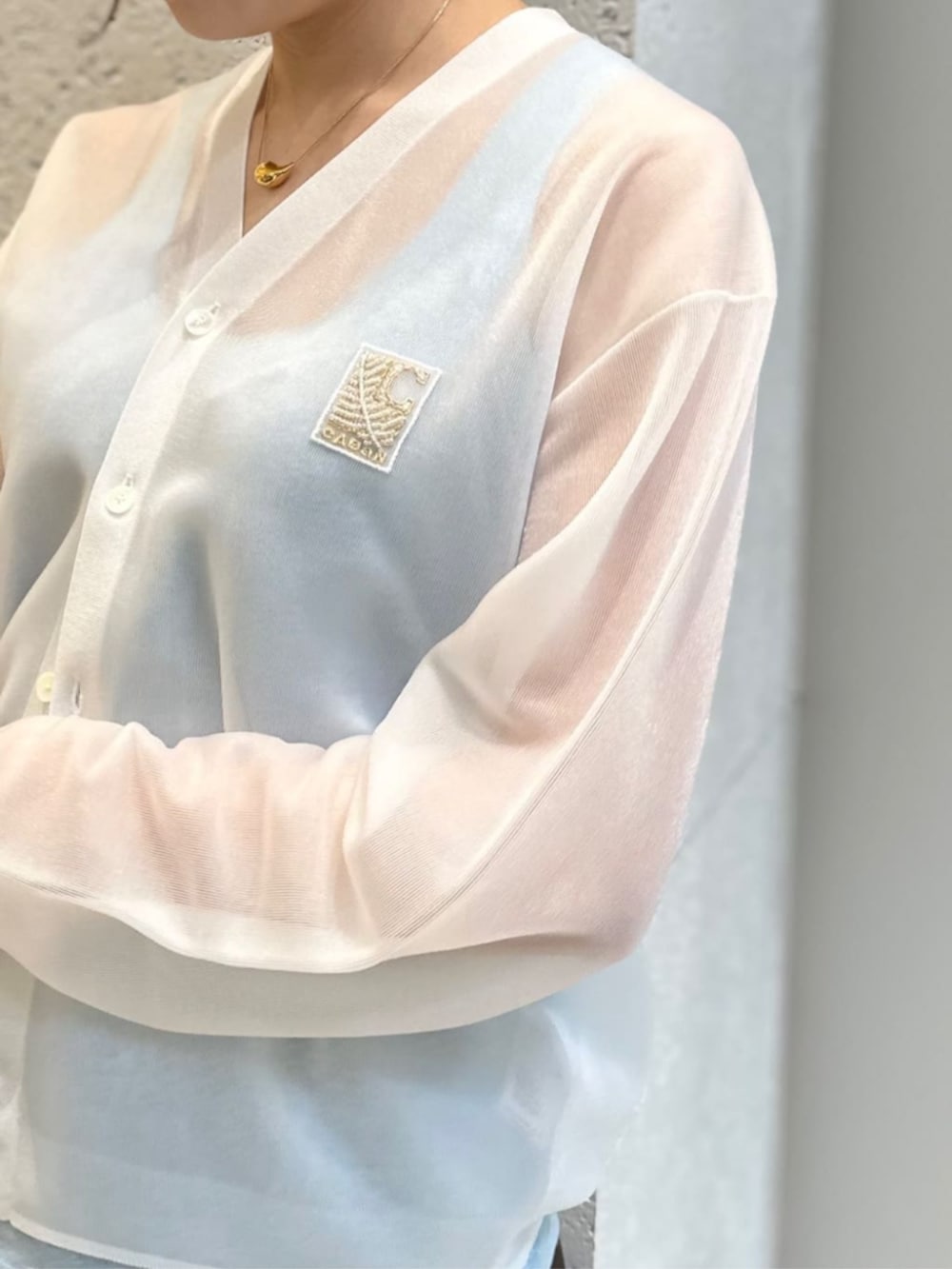 ブラック系のサンダル、ブラウン系のスカート、ホワイト系のニット/セーターを着用したレディースの夏コーディネートの2枚目の写真