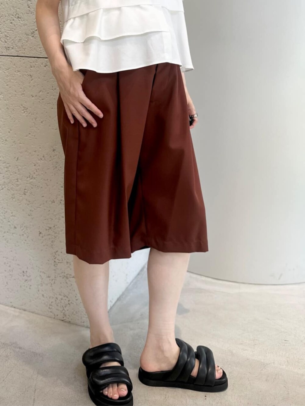 グリーン系のショルダーバッグ、ブラック系のサンダル、ホワイト系のシャツ/ブラウスを着用したレディースの夏コーディネートの4枚目の写真