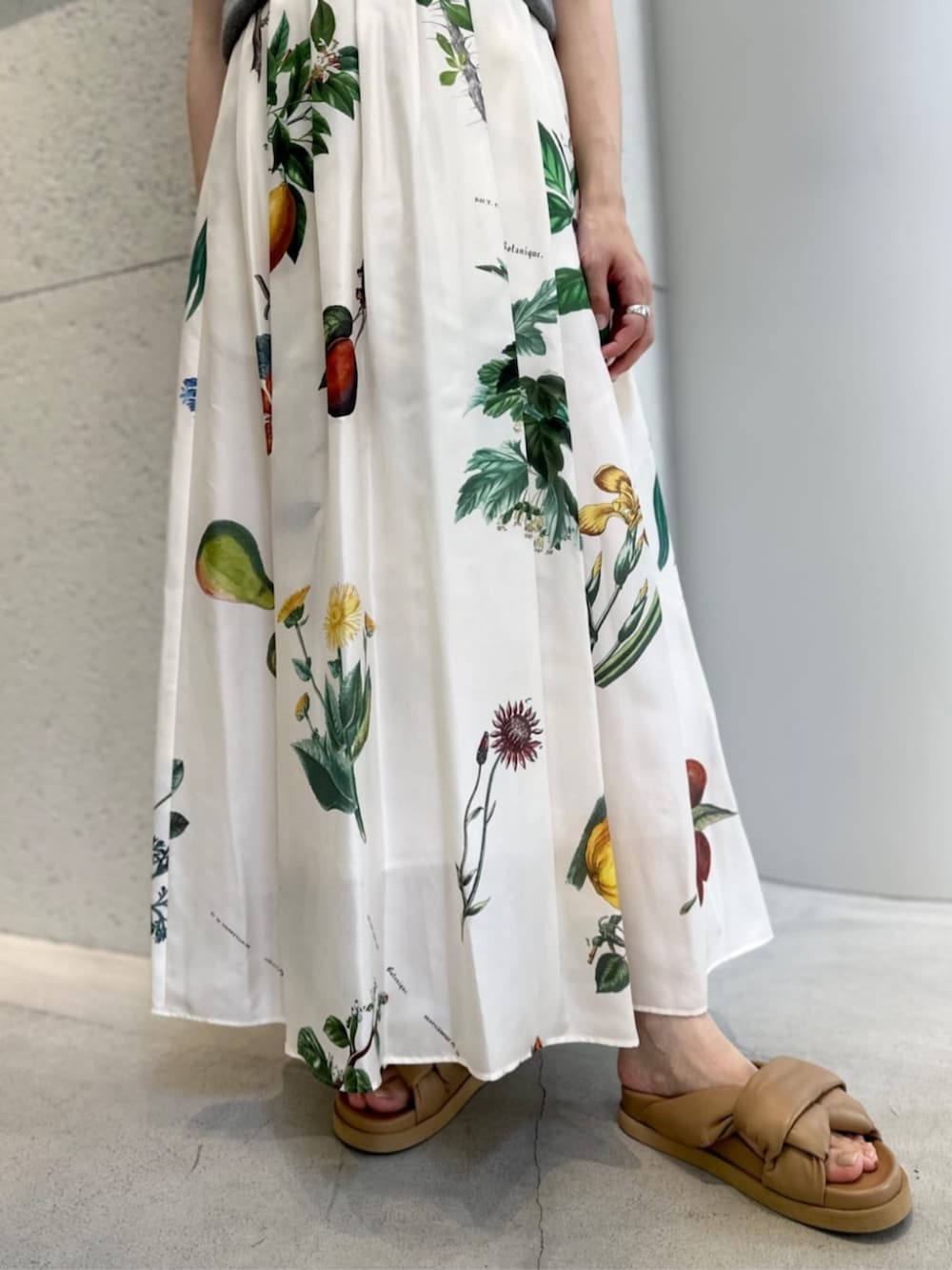 ベージュ系のサンダル、グレー系のニット/セーター、ホワイト系のスカートを着用したレディースの夏コーディネートの3枚目の写真