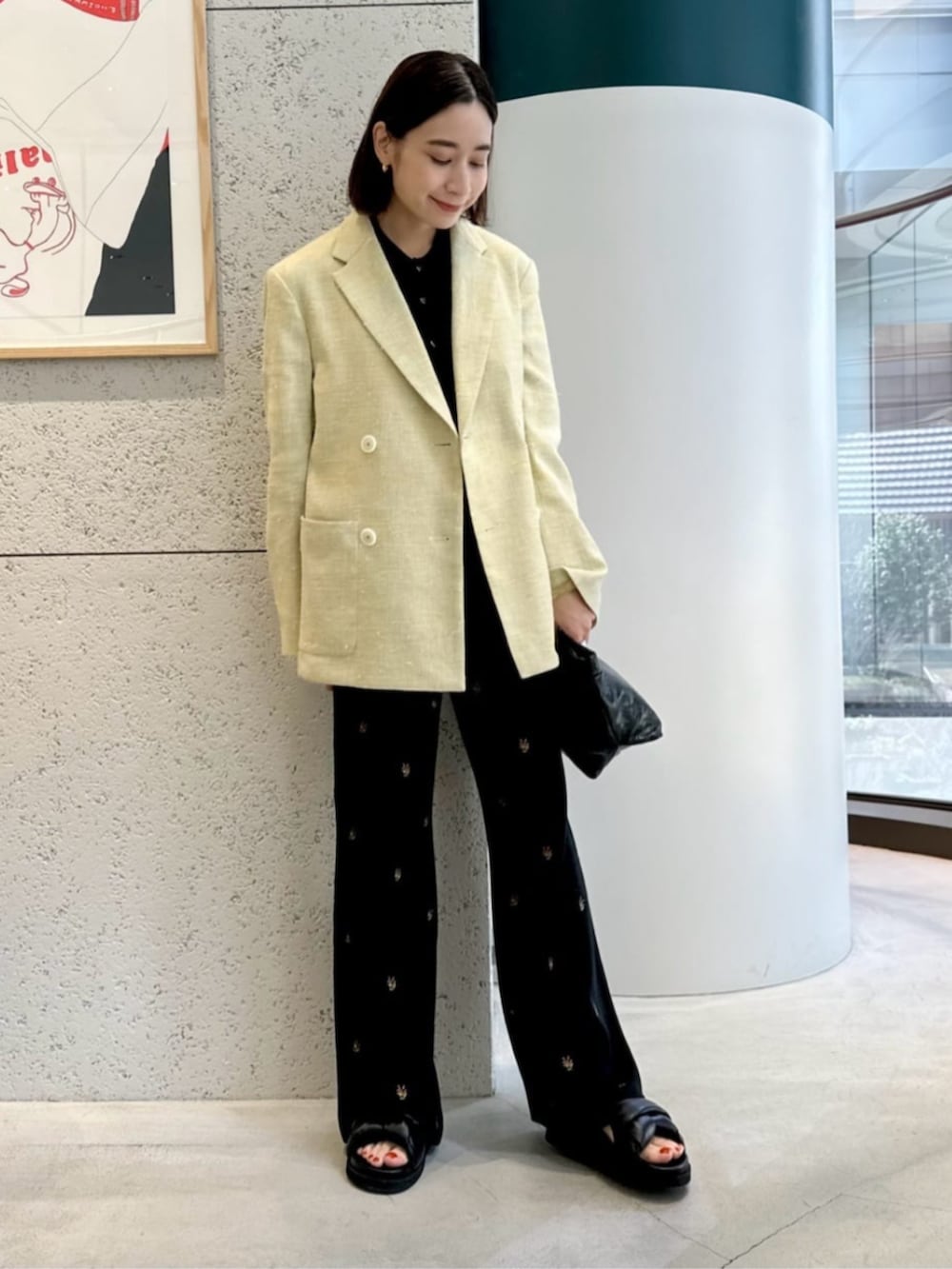 ブラック系のサンダル、イエロー系のテーラードジャケット、ブラック系のカーディガン/ボレロを着用したレディースの春コーディネートの2枚目の写真