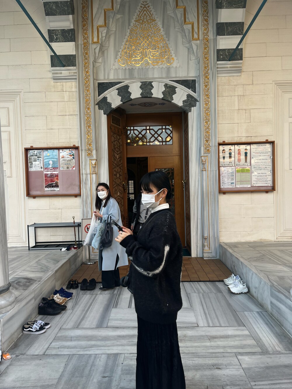 ブラック系のニット/セーター、ブラック系のスカート、ブラック系のショルダーバッグを着用したレディースの秋コーディネートの2枚目の写真