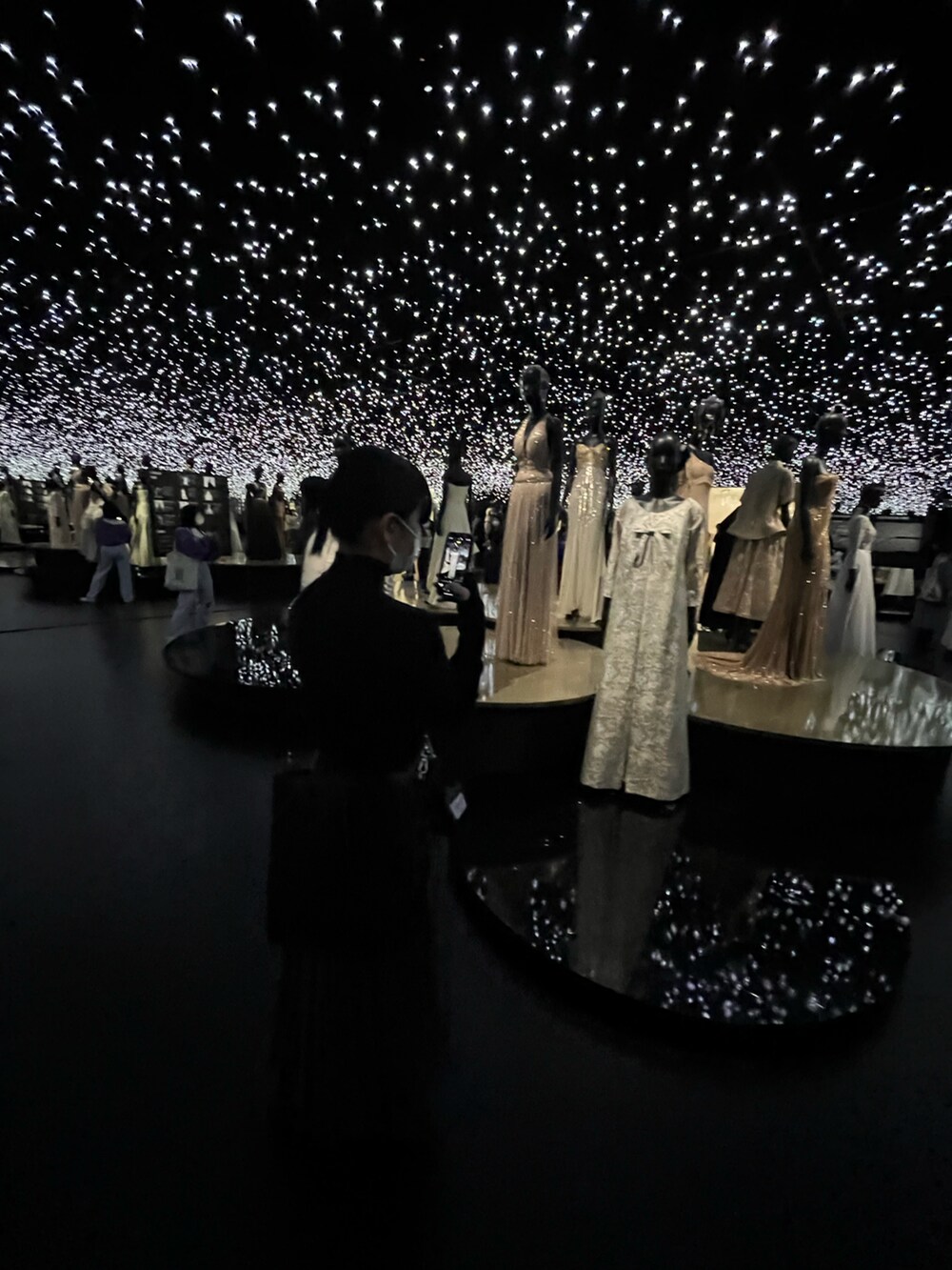 グレー系のスカート、ブラック系のトートバッグ、ブラック系のニット/セーターを着用したレディースの春コーディネートの4枚目の写真