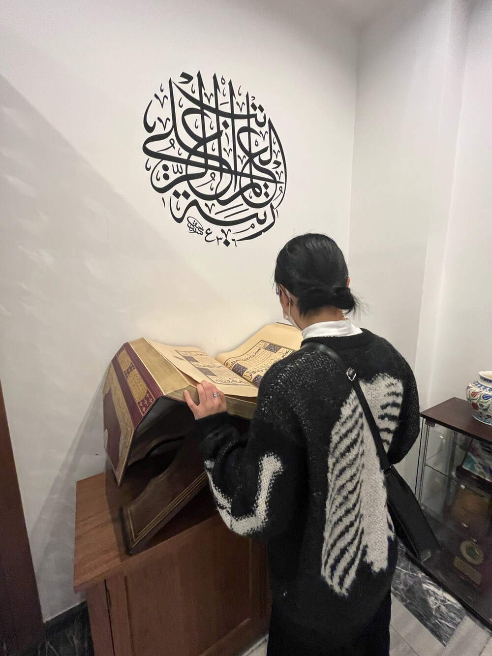 ブラック系のニット/セーター、ブラック系のスカート、ブラック系のショルダーバッグを着用したレディースの秋コーディネートの3枚目の写真