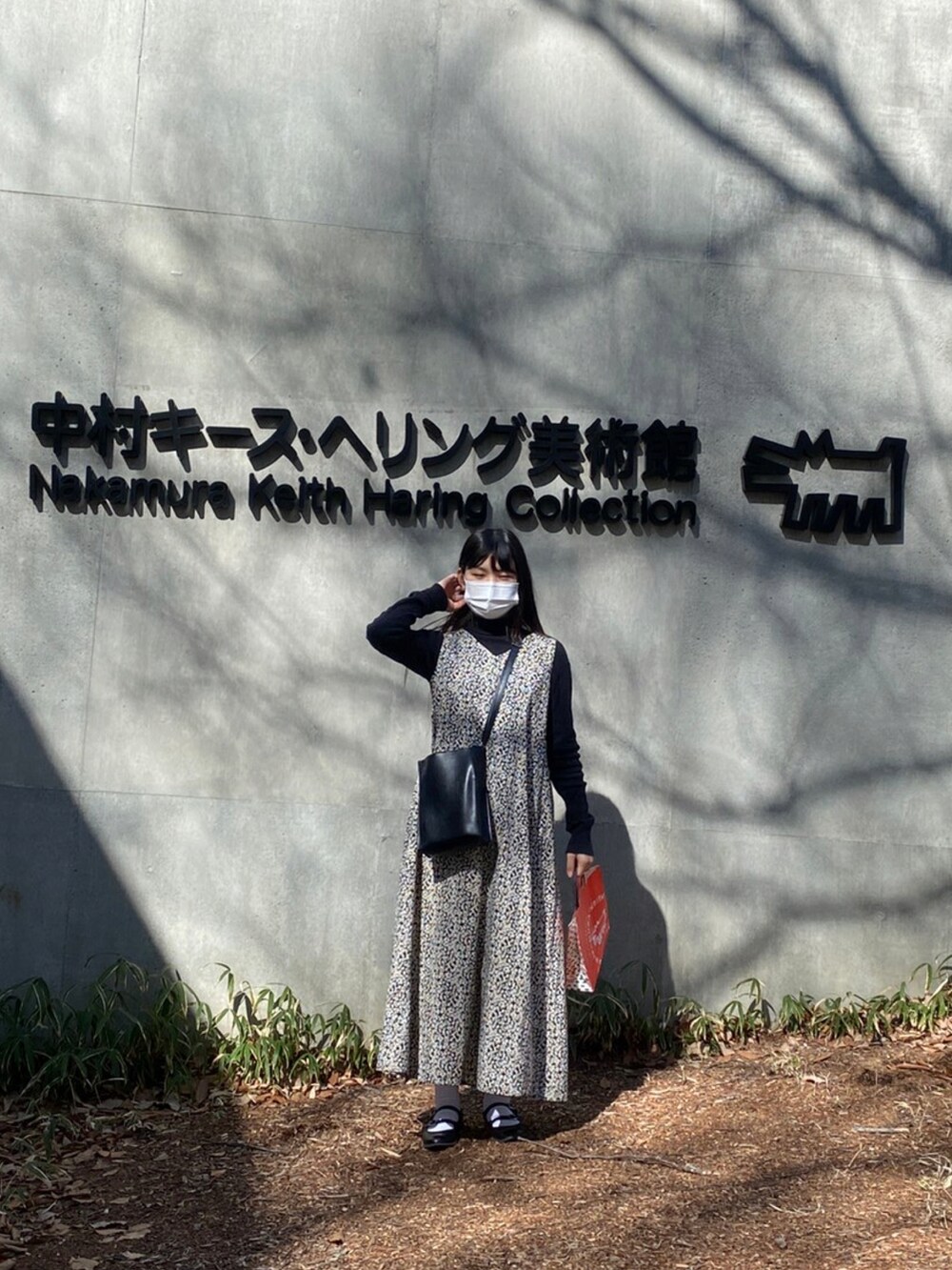 ブラック系のショルダーバッグ、ブラック系のニット/セーター、ブラック系のパンプスを着用したレディースの秋コーディネートの3枚目の写真