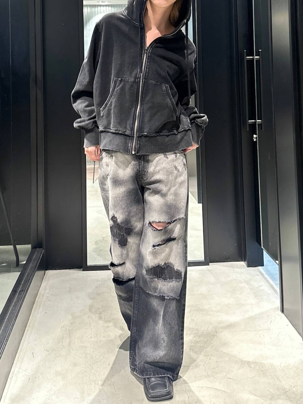 ブラック系のデニムパンツ、ブラック系のパーカー、ブラック系のキャップを着用したメンズの秋コーディネートの4枚目の写真