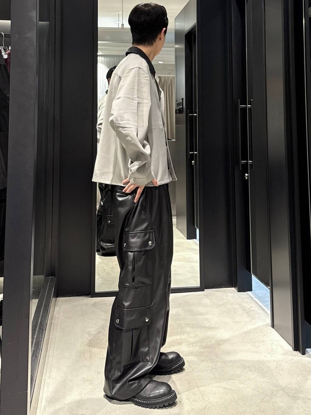 ブラック系のタンクトップ、ブラック系のカーゴパンツ、ブラック系のブーツを着用したメンズの秋コーディネートの2枚目の写真