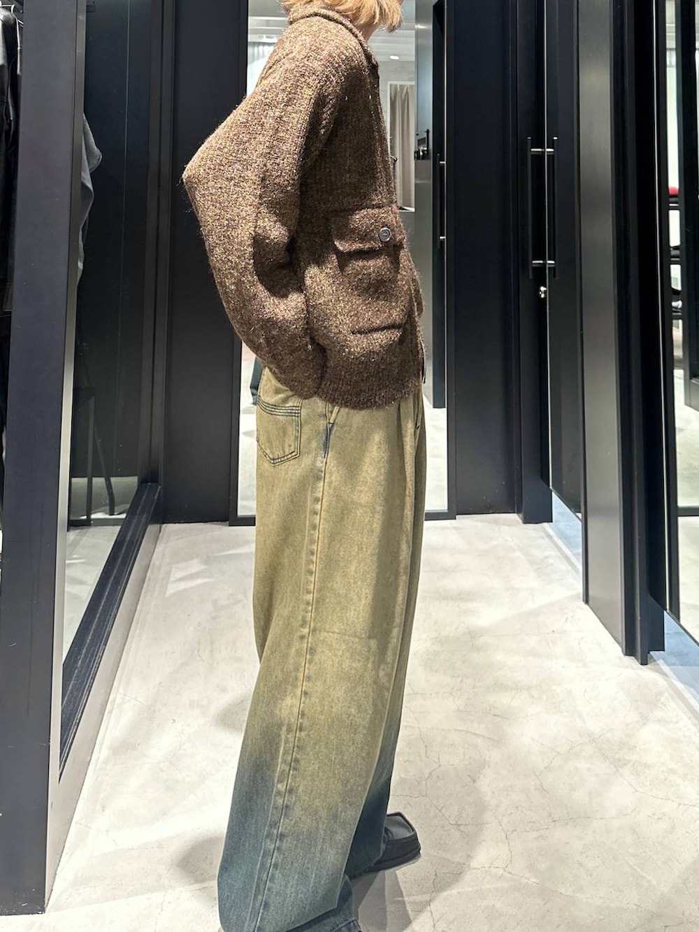 グリーン系のデニムパンツ、イエロー系のニット/セーター、シルバー系のネックレスを着用したメンズの秋コーディネートの3枚目の写真