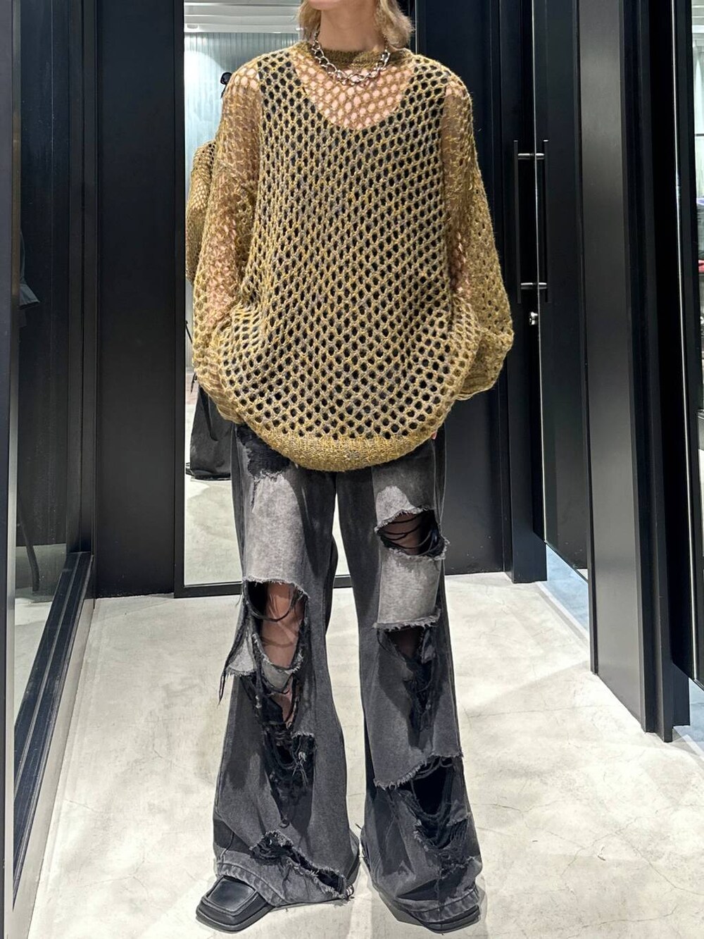 ブラック系のデニムパンツ、イエロー系のニット/セーター、シルバー系のネックレスを着用したメンズの秋コーディネートの2枚目の写真