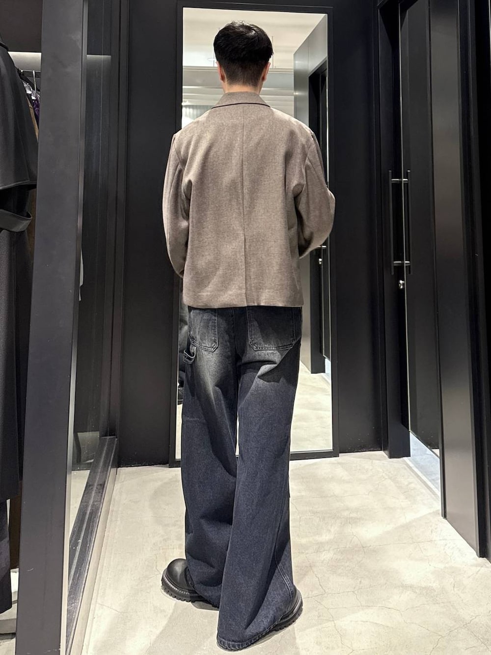 ブラック系のブーツ、ブルー系のデニムパンツ、ブラウン系のテーラードジャケットを着用したメンズの秋コーディネートの3枚目の写真