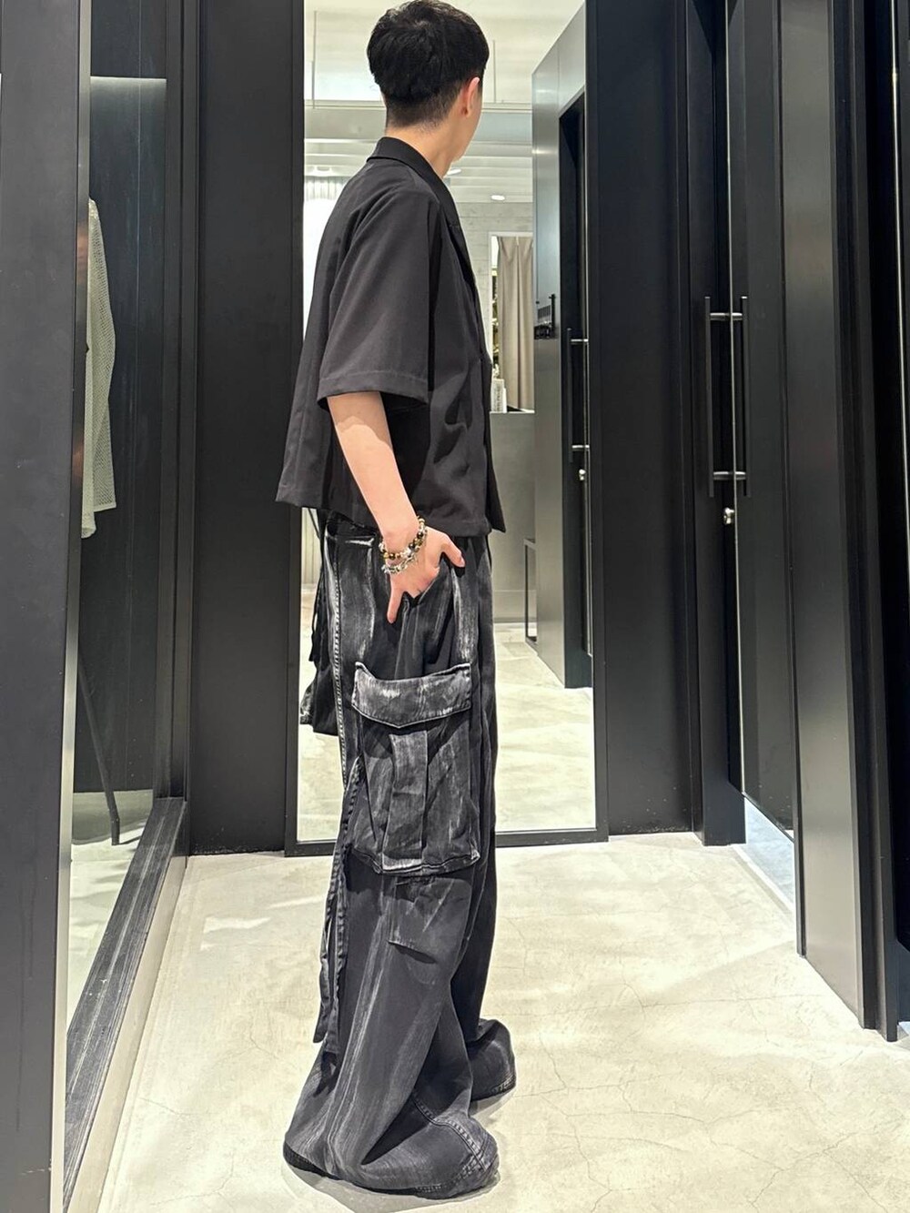 ブラック系のカーゴパンツ、ブラック系のサンダル、ブラック系のタンクトップを着用したメンズの夏コーディネートの2枚目の写真