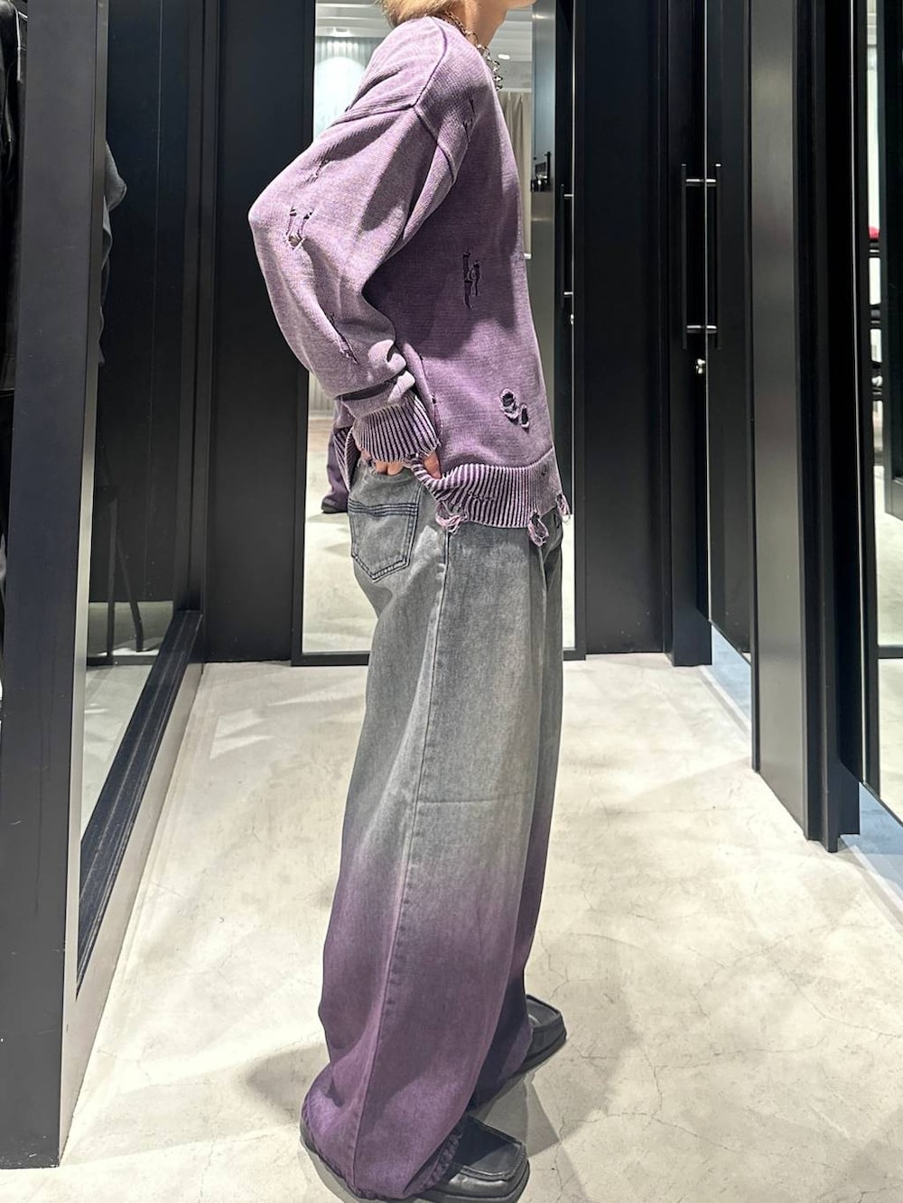 パープル系のデニムパンツ、パープル系のニット/セーター、シルバー系のネックレスを着用したメンズの秋コーディネートの4枚目の写真