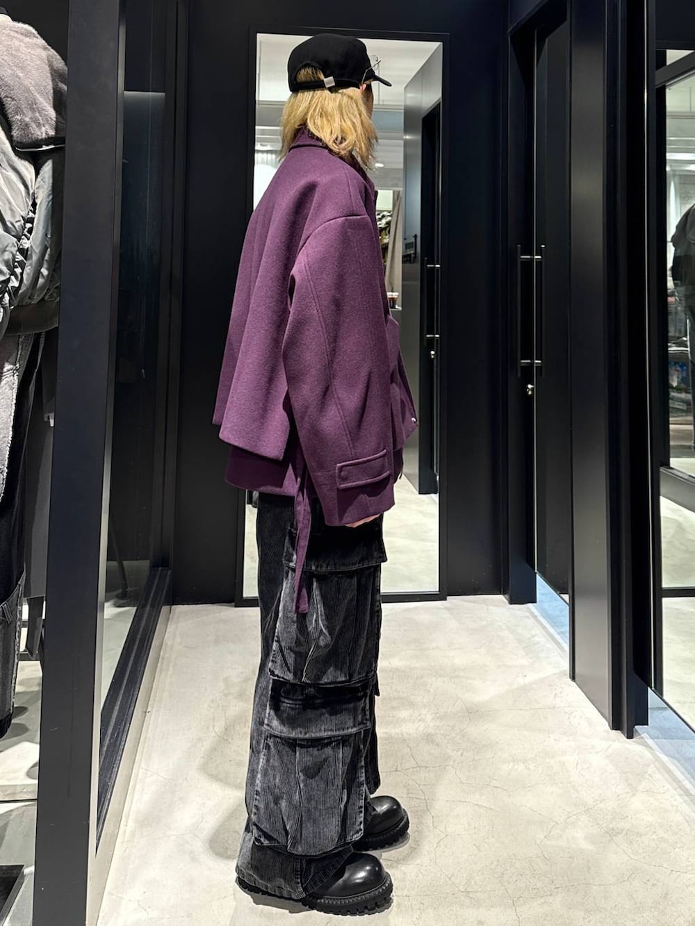 パープル系のブルゾン、ブラック系のその他シューズ、グレー系のカーゴパンツを着用したメンズの秋コーディネートの2枚目の写真