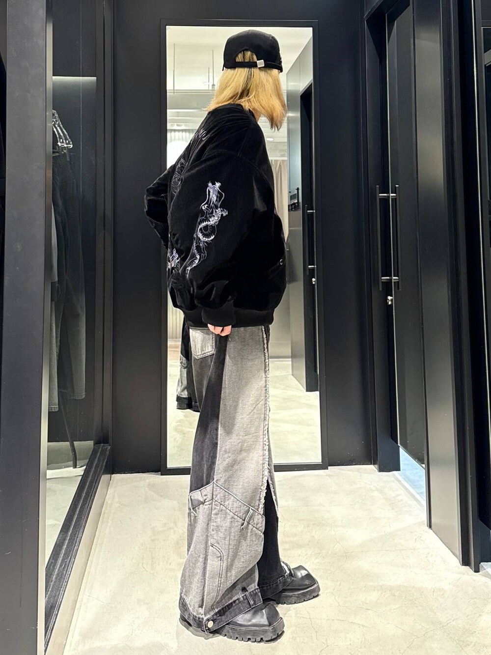 ブラック系のデニムパンツ、ブラック系のブルゾン、ブラック系のキャップを着用したメンズの秋コーディネートの2枚目の写真