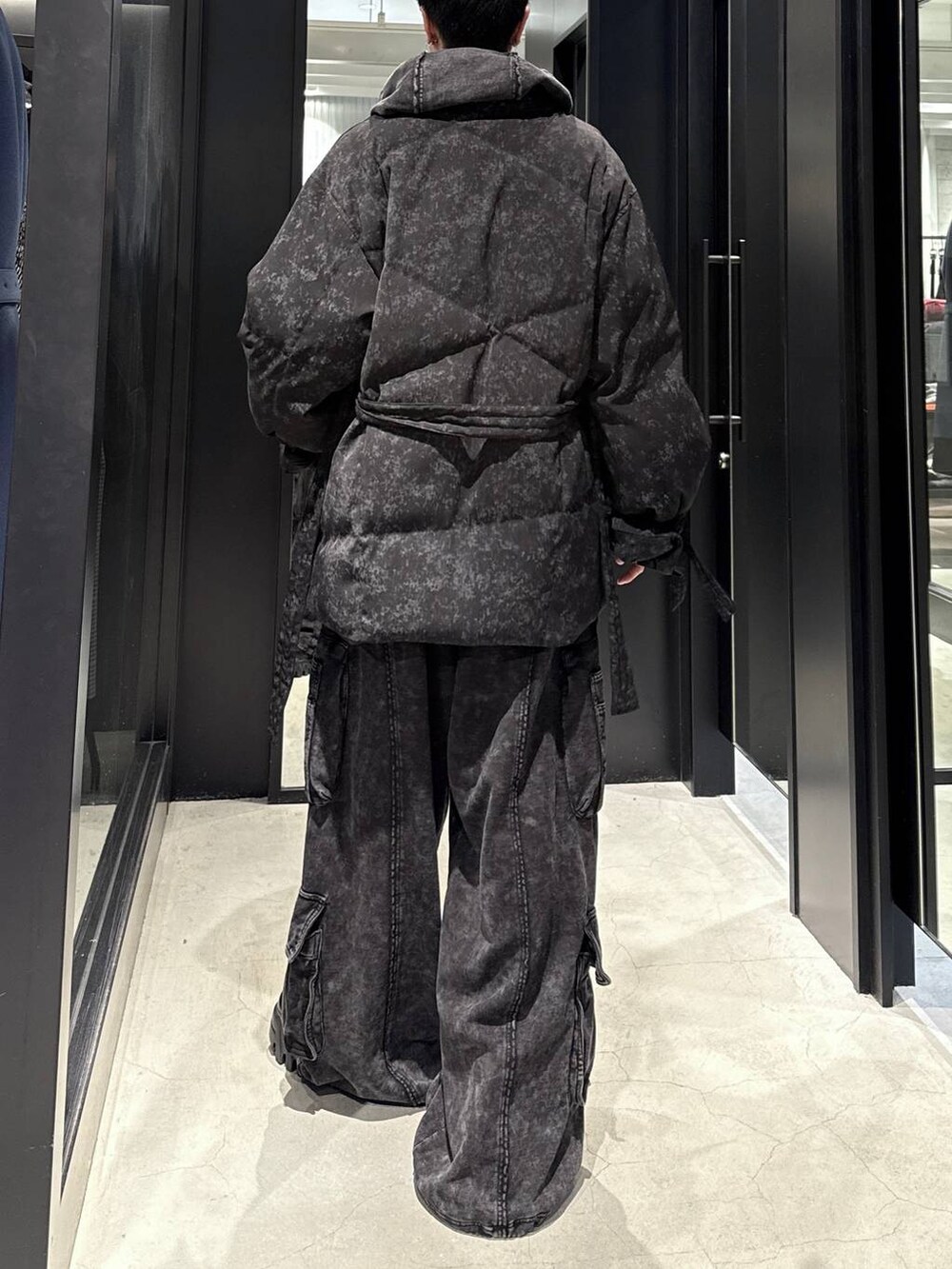 ブラック系のスウェットパンツ、ブラック系のパーカー、グレー系のダウンジャケット/コートを着用したメンズの冬コーディネートの3枚目の写真