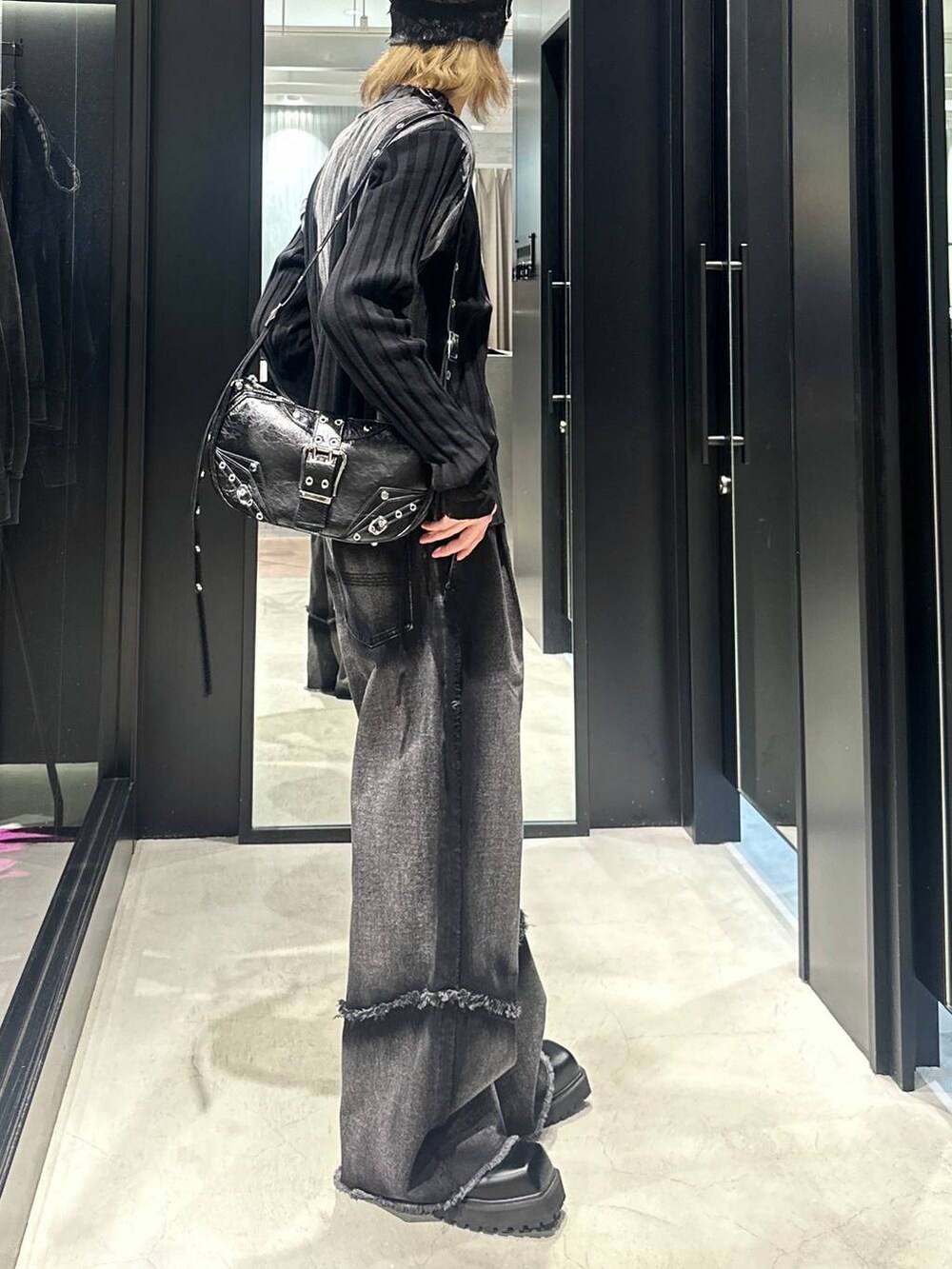 ブラック系のデニムパンツ、ブラック系のショルダーバッグ、ブラック系のニット/セーターを着用したメンズの秋コーディネートの2枚目の写真