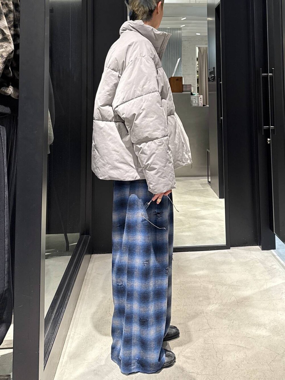 グレー系のブルゾン、ブルー系のその他パンツ、シルバー系のネックレスを着用したメンズの冬コーディネートの2枚目の写真