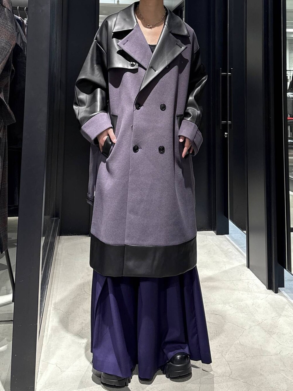 パープル系のトレンチコート、パープル系のスラックスを着用したメンズの秋コーディネートの3枚目の写真