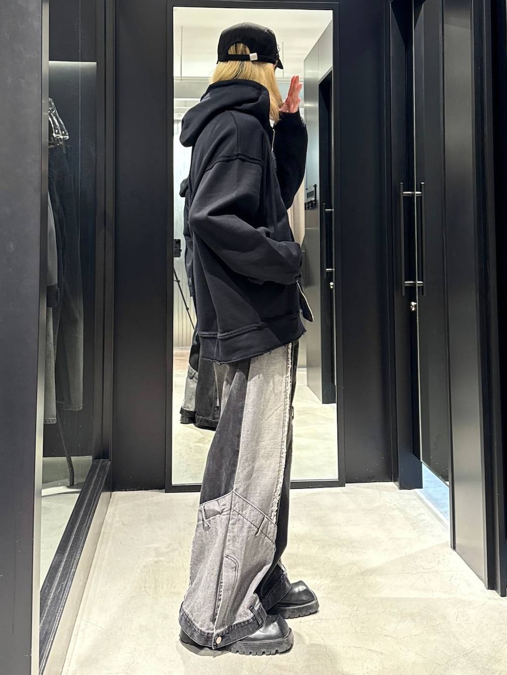 ブラック系のデニムパンツ、ブラック系のパーカー、ブラック系のキャップを着用したメンズの秋コーディネートの2枚目の写真