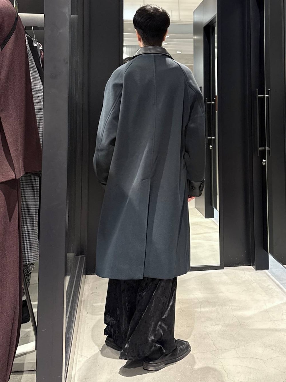 グリーン系のステンカラーコート、ブラック系のその他パンツ、ブラック系のスウェットを着用したメンズの秋コーディネートの4枚目の写真