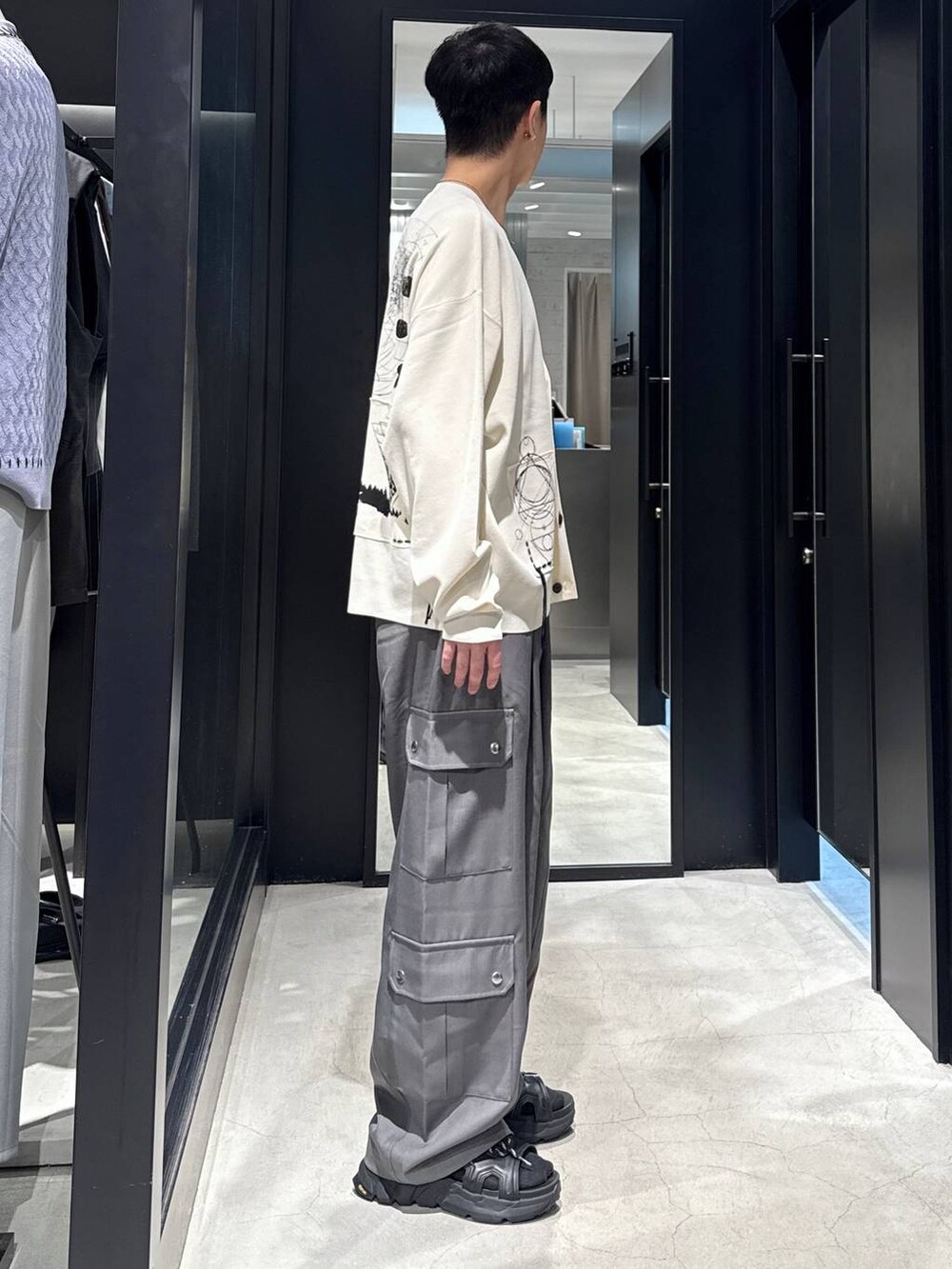 ブラック系のサンダル、ブラック系のタンクトップ、グレー系のカーゴパンツを着用したメンズの夏コーディネートの2枚目の写真