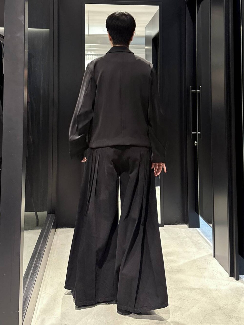 ホワイト系のTシャツ/カットソー、ブラック系のテーラードジャケット、ブラック系のデニムパンツを着用したメンズの秋コーディネートの3枚目の写真