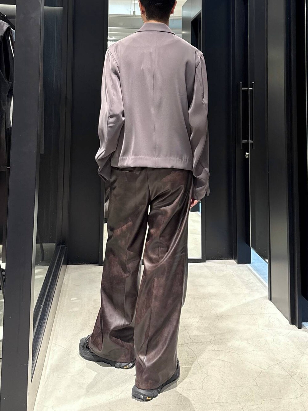 ブラック系のサンダル、ブラック系のタンクトップ、グレー系のテーラードジャケットを着用したメンズの夏コーディネートの5枚目の写真