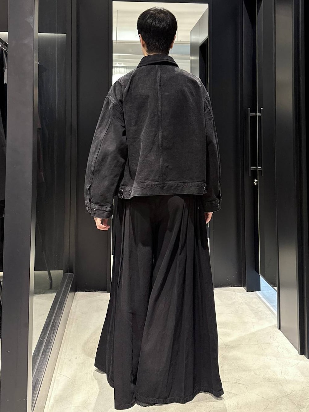 ホワイト系のTシャツ/カットソー、ブラック系のデニムパンツ、ブラック系のブーツを着用したメンズの秋コーディネートの3枚目の写真