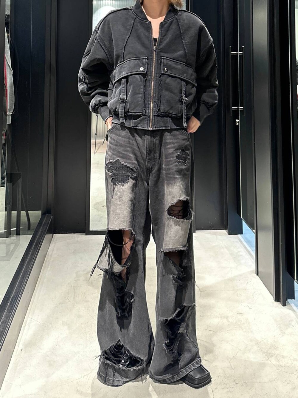 ブラック系のデニムパンツ、ブラック系のブルゾン、グレー系のニットキャップ/ビーニーを着用したメンズの秋コーディネートの4枚目の写真