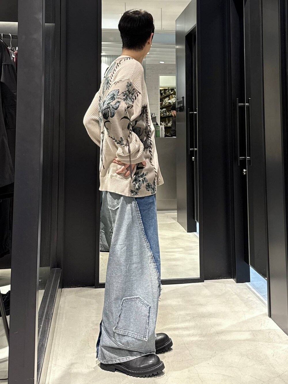 ブラック系のタンクトップ、ブルー系のデニムパンツ、グレー系のカーディガン/ボレロを着用したメンズの秋コーディネートの2枚目の写真