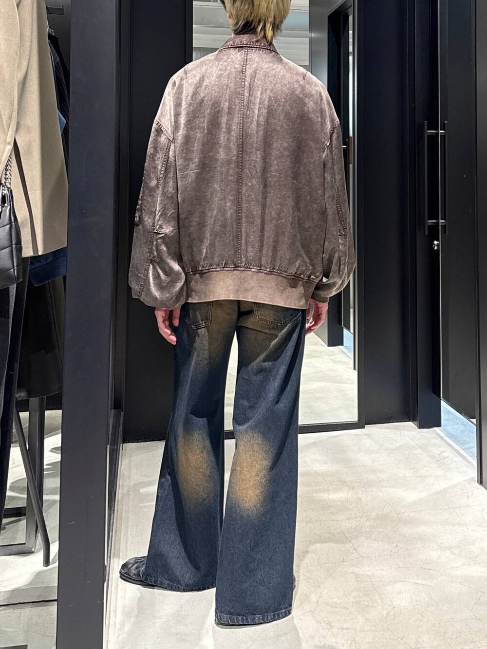 ブルー系のデニムパンツ、ブラック系のTシャツ/カットソー、ブラウン系のブルゾンを着用したメンズの冬コーディネートの3枚目の写真