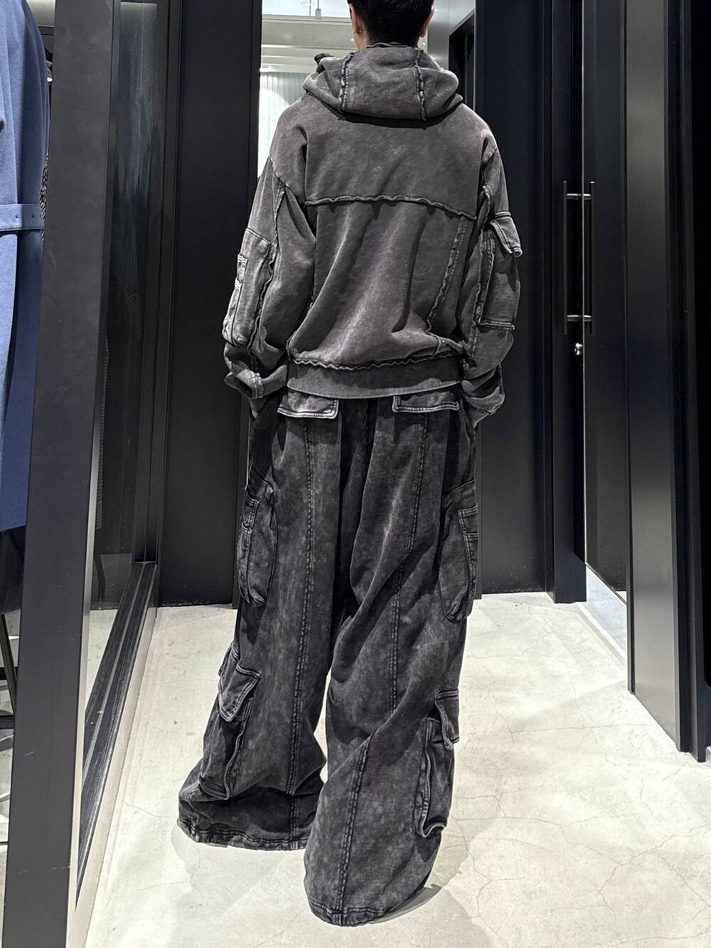 ブラック系のスウェットパンツ、ブラック系のパーカー、ホワイト系のネックレスを着用したメンズの冬コーディネートの3枚目の写真