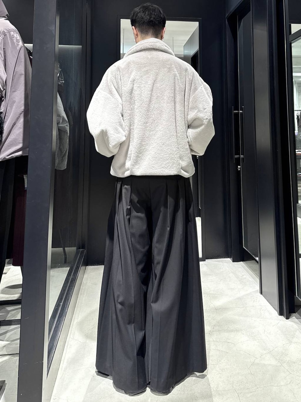 グレー系のブルゾン、ブラック系のスラックスを着用したメンズの冬コーディネートの3枚目の写真