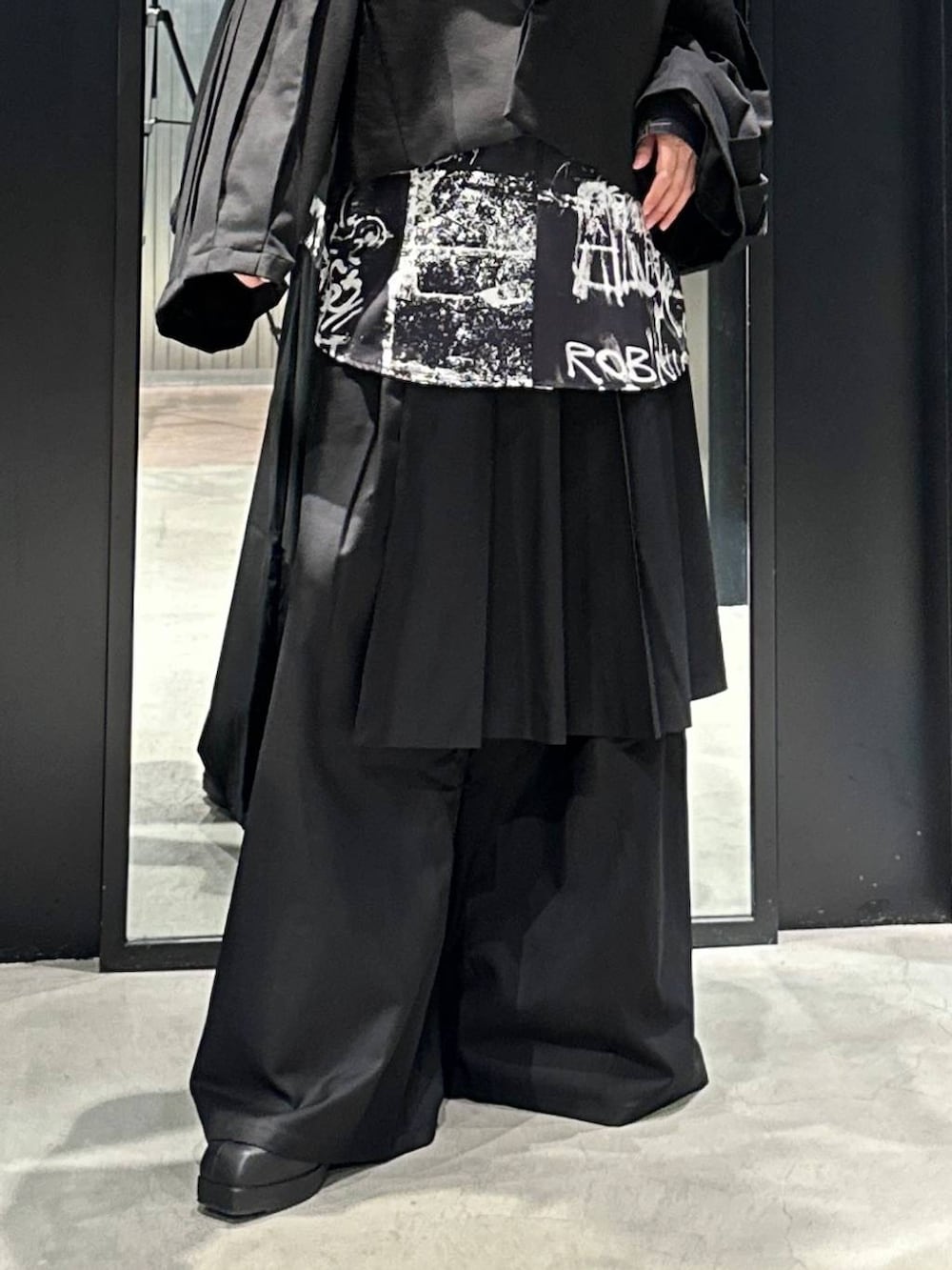 ブラック系のスラックス、ブラック系のブーツ、ブラック系のテーラードジャケットを着用したメンズの秋コーディネートの3枚目の写真