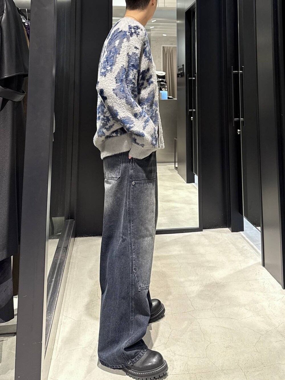 グレー系のカーディガン/ボレロ、ブラック系のブーツ、ブルー系のデニムパンツを着用したメンズの秋コーディネートの2枚目の写真