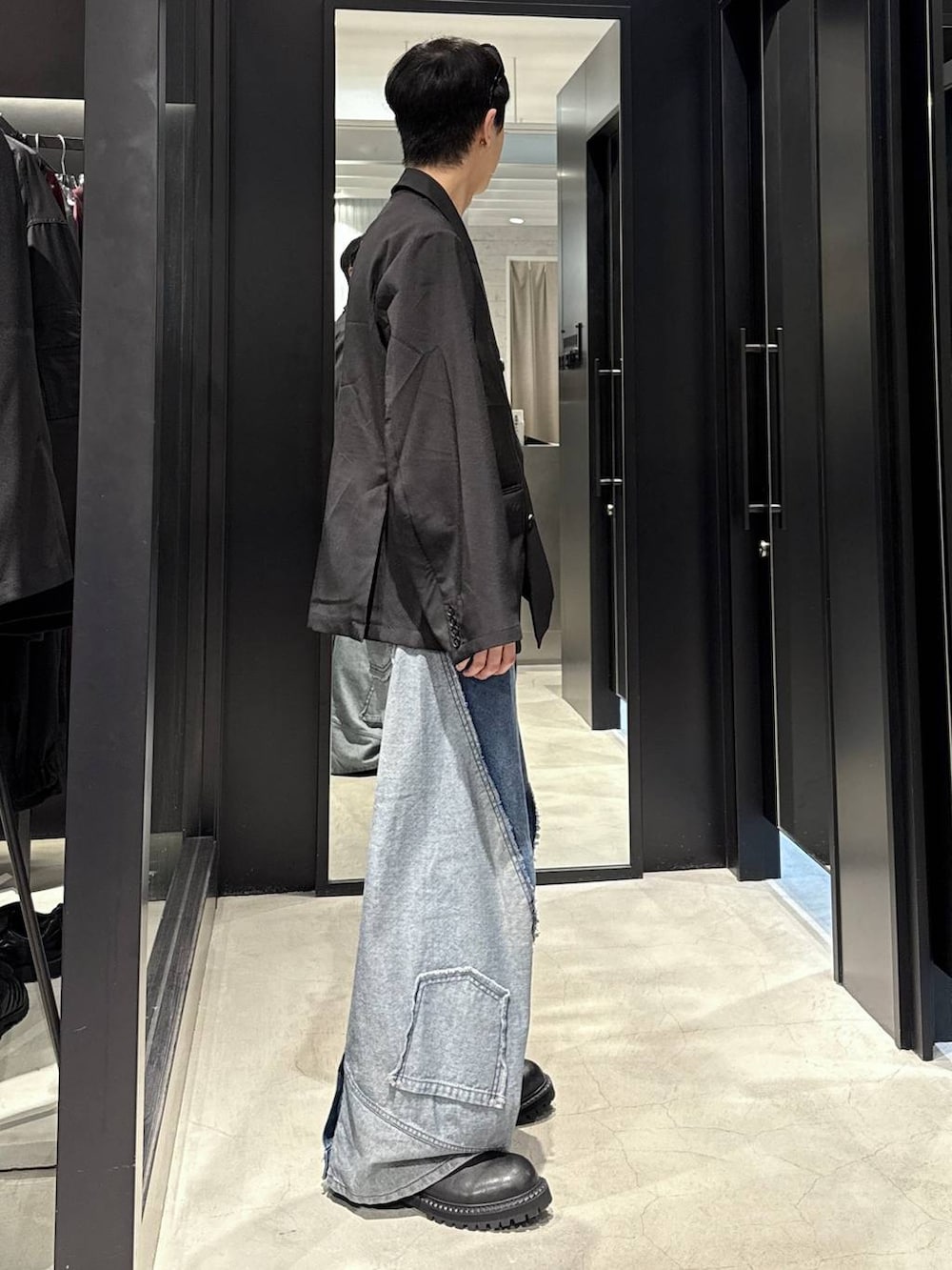 ブラック系のタンクトップ、ブルー系のデニムパンツ、ブラック系のテーラードジャケットを着用したメンズの秋コーディネートの2枚目の写真