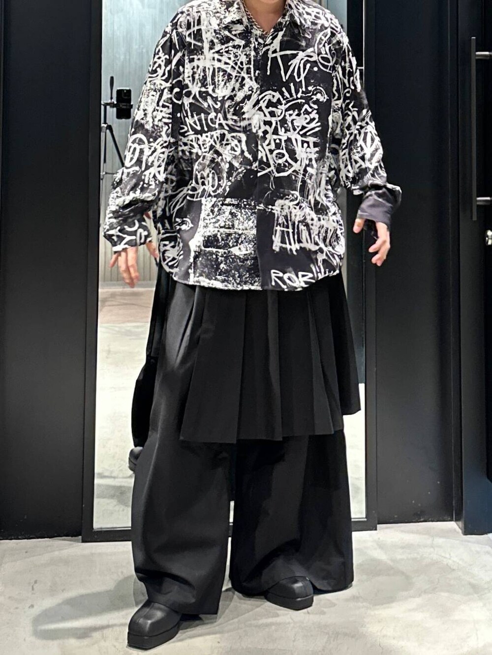 ブラック系のスラックス、ブラック系のブーツ、ブラック系のシャツ/ブラウスを着用したメンズの秋コーディネートの4枚目の写真